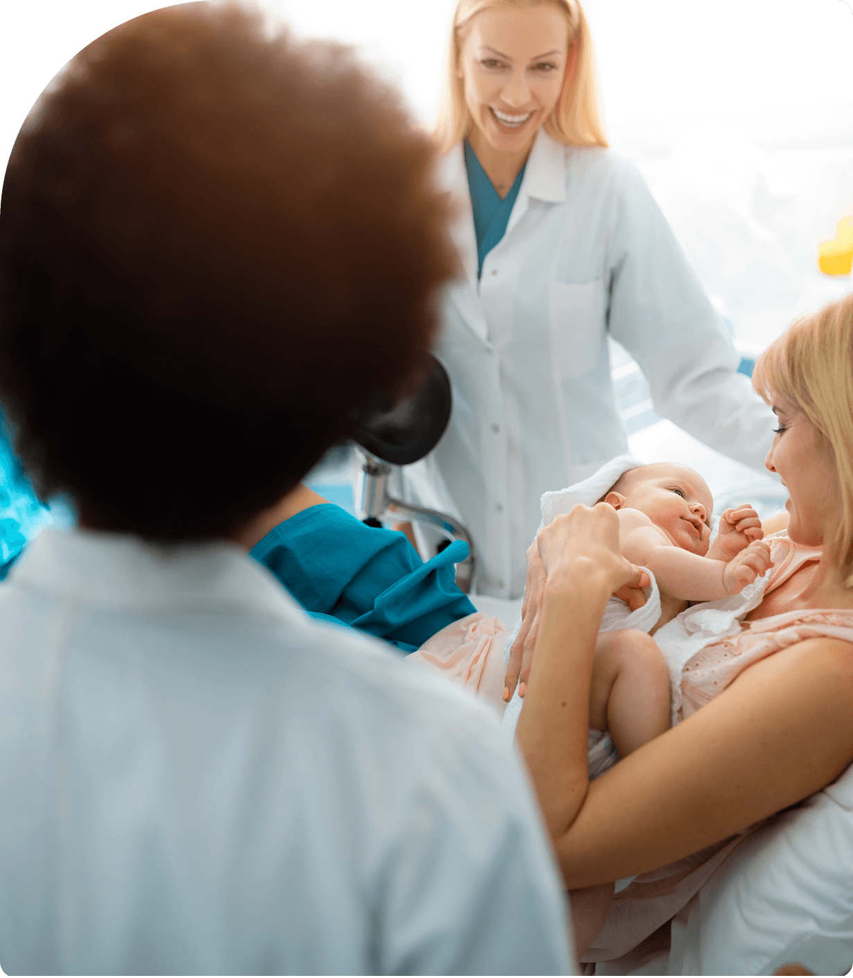 Rectangle 2 (2) (2) Mother holding baby, smiling with medical staff.